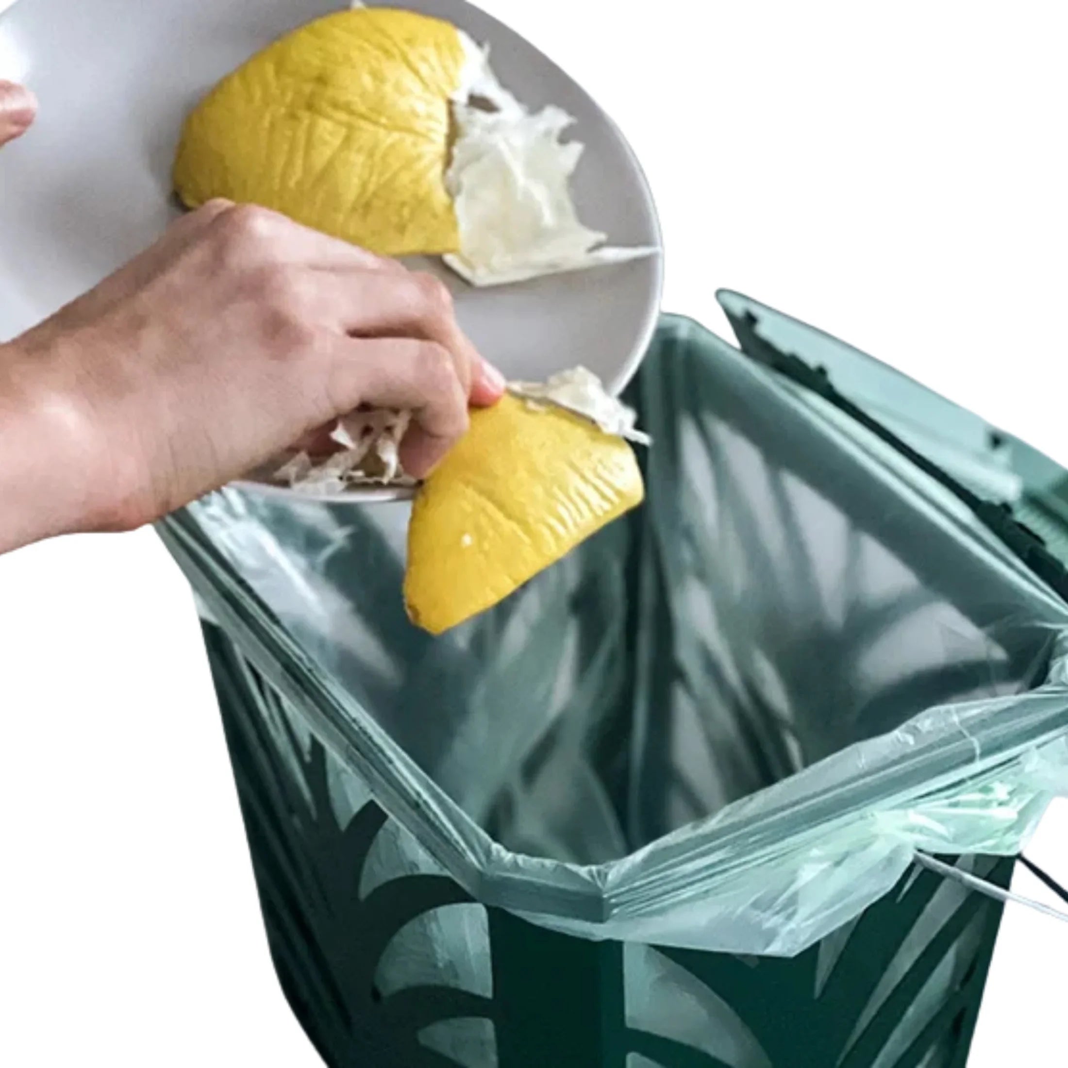 Hand scraping food waste from plate into green compostable trash bag